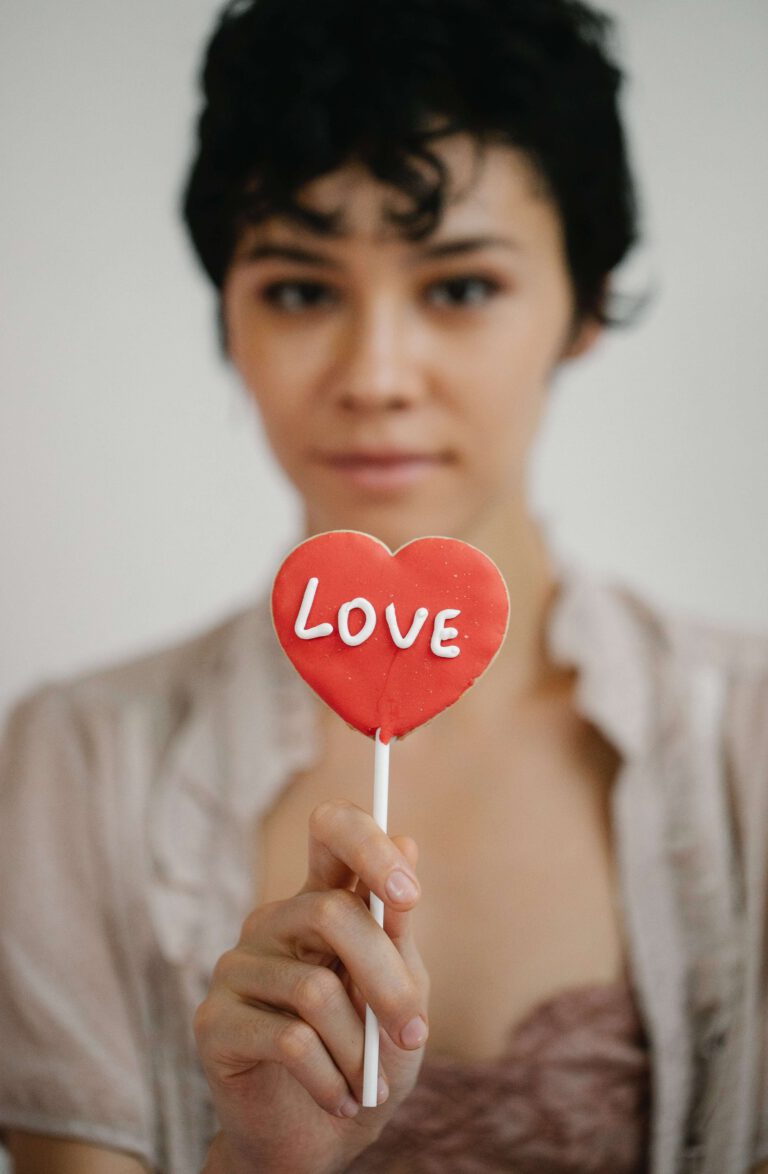 A woman holding a lollipop with the word love on it.